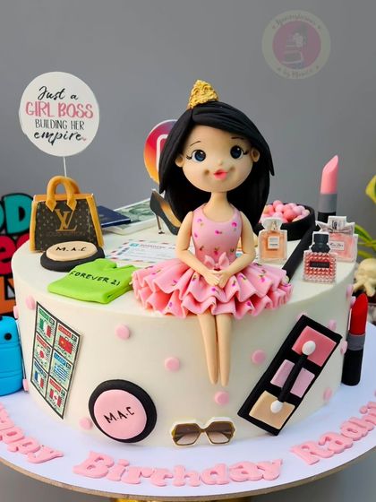A girl boss cake for a marketing agency owner, featuring a custom figurine surrounded by makeup, luxury brands, and travel elements.