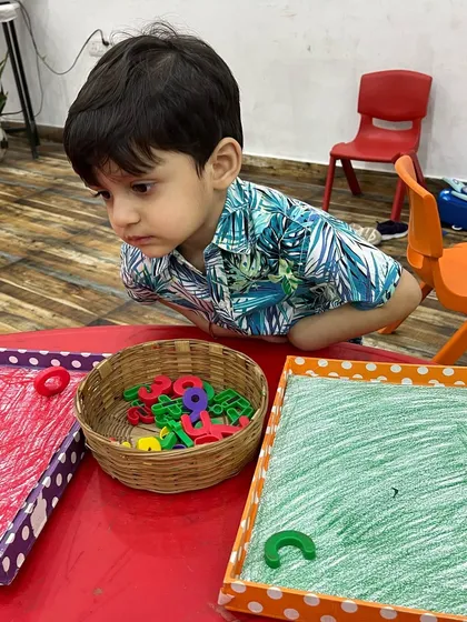 Sorting magnetic letters into colored trays. This simple activity helps with color recognition and letter identification.