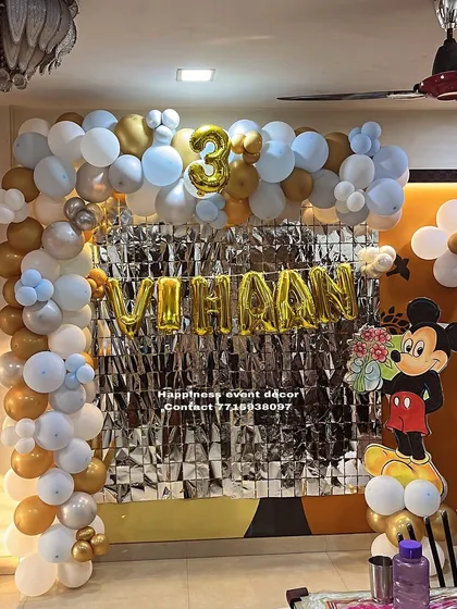 A Mickey Mouse themed L-arch decoration for a 3rd birthday at home. The silver, blue, and gold balloons create a classic and festive look.