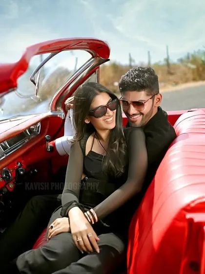 An intimate pre-wedding portrait of the couple in their vintage ride. This shot highlights their connection and the classic cool of the car's interior.