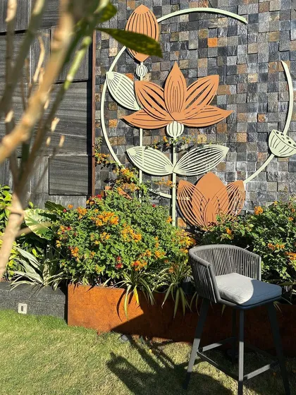 Art is a vital part of my landscape narratives. This lotus installation, set against a textured stone wall and corten steel planter, serves as a focal point, symbolizing beauty and prosperity while enhancing the garden's aesthetic appeal.