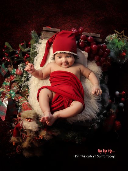 "The cutest Santa today." This overhead shot captures the full festive scene, with the baby as the adorable centerpiece.
