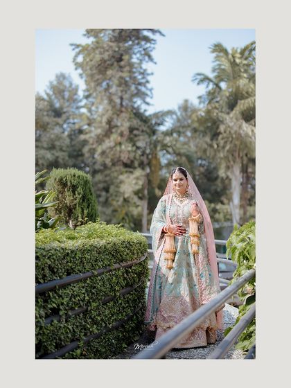 A beautiful outdoor portrait of the Sikh bride, with the lush greenery providing a stunning contrast to her elegant wedding attire.
