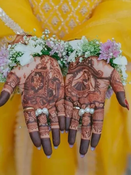 The final look after the henna has been applied, adorned with beautiful floral jewelry. This shows how the mehndi becomes a central part of the bride's overall look.