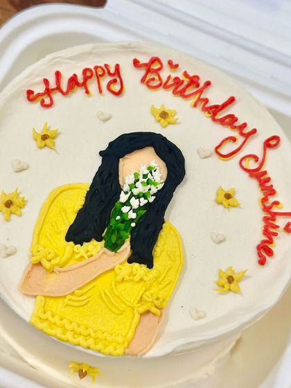 A sunshine-yellow bento cake with a hand-painted portrait to brighten someone's birthday. We love turning your photos and ideas into sweet, edible illustrations.