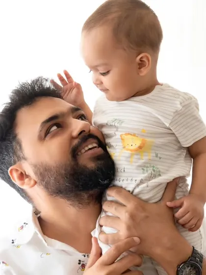 A candid father and son portrait captured with bright, natural light. The focus is on the loving gaze between them, creating a genuine moment.