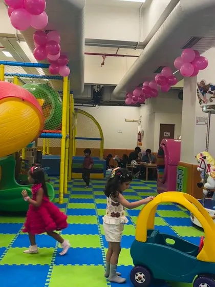 Watch as children navigate the play area, pushing a ride on car and interacting with each other. I love seeing them develop social skills and have fun together in this safe, stimulating environment.