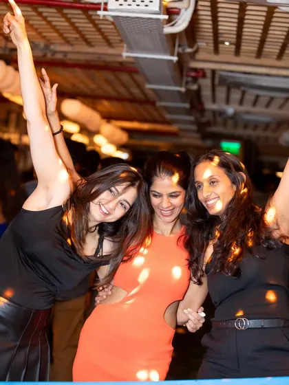 Three friends dancing together, having the time of their lives at VIBE CHECK Friday.