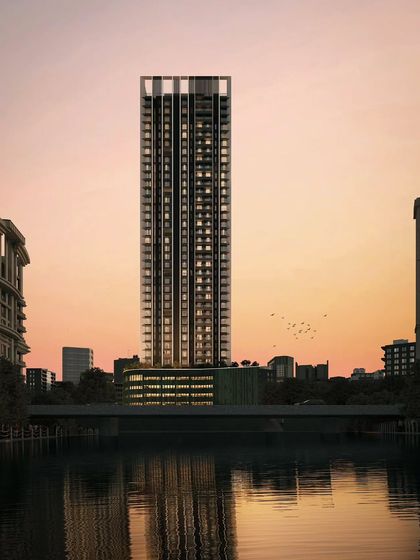 A view of the sustainable residential tower from across the water. The reflection emphasizes its verticality and the careful composition of its façade, designed to be both beautiful and environmentally responsive.