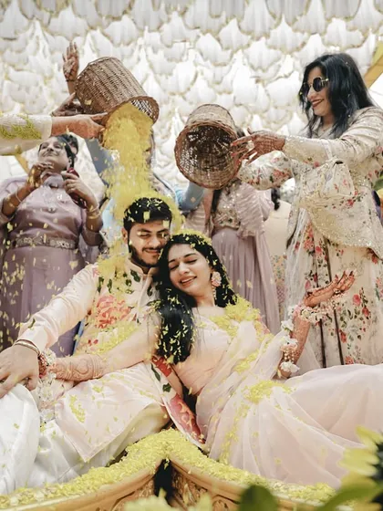 A beautiful moment of a 'phoolon ki haldi' where the couple is showered with flower petals by their bridesmaids and family.