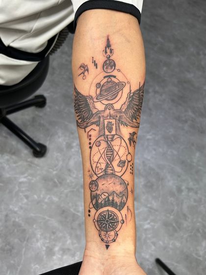 A custom forearm sleeve that represents the universe within us. It features an angel, planets, DNA, mountains, and a compass, symbolizing the connection between humanity, nature, and the cosmos.