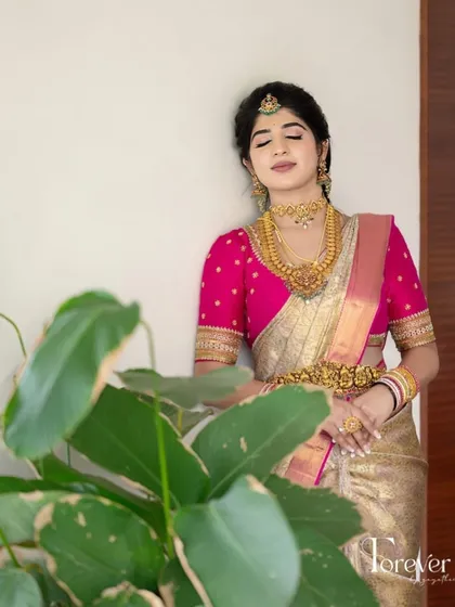 A tranquil moment with a bride in her gold and pink Kanchivaram ensemble. The simple elegance of the embroidered pink blouse allows the jewelry and saree to shine.
