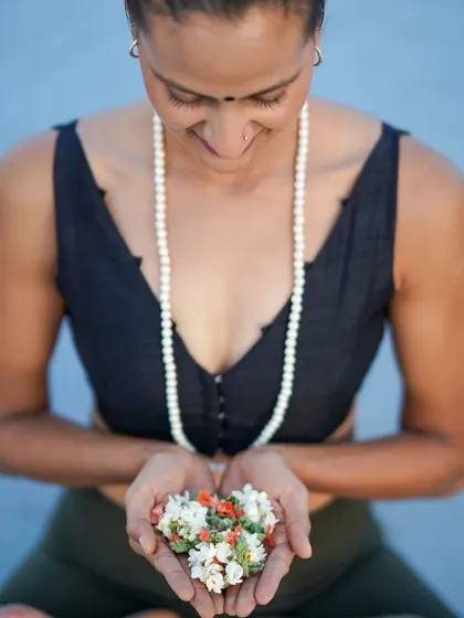 A moment of peace, holding flowers as an offering. This image captures the gentle, devotional side of my practice and my connection to the traditions of yoga.