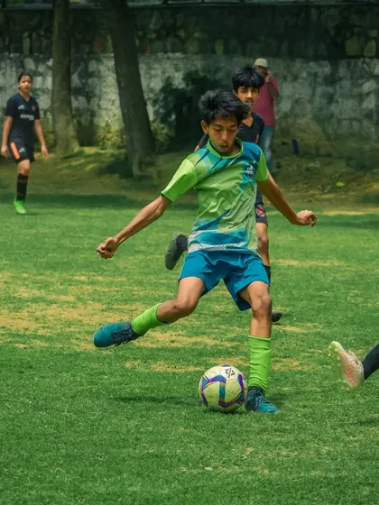 A player controls the ball, looking to make a pass to a teammate.