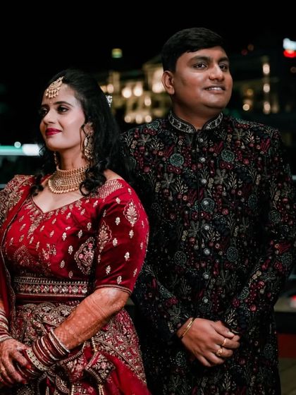 A beautifully lit evening shot of the couple, with the city lights providing a lovely background.