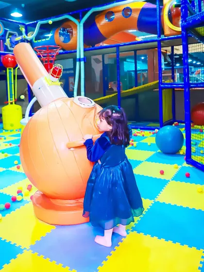 A little princess explores the ball cannon machine, a key feature in our play area that adds an element of surprise and delight to parties.