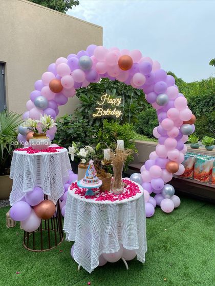 A wider view of the pastel outdoor birthday setup, showing the beautiful garden setting.
