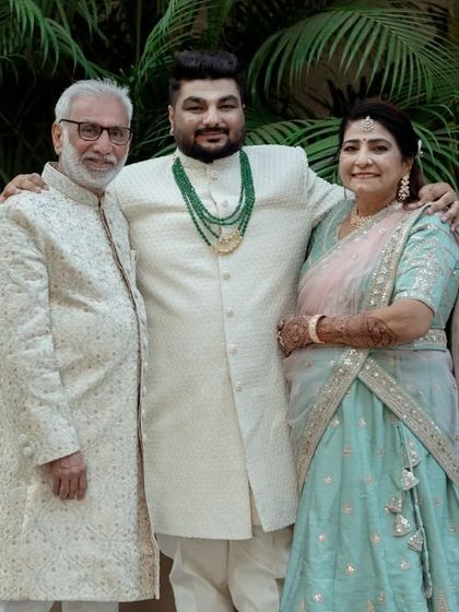 A family portrait showcasing three different custom outfits. The groom wears a classic bandhgala, while his father wears a sherwani with subtle embroidery, demonstrating my range for family attire.