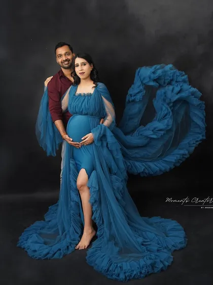 A powerful and artistic couple's portrait. The flowing blue fabric creates a dramatic effect, framing the couple in this stunning studio shot.