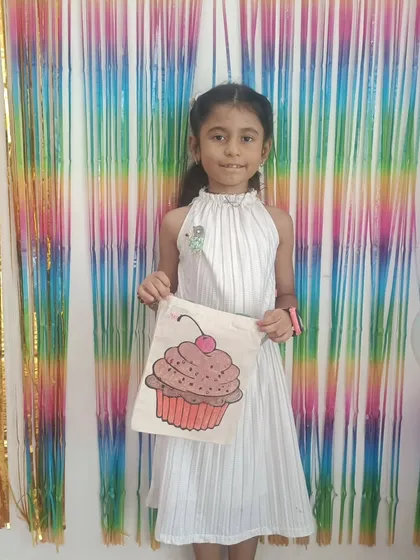 The birthday girl, Uma, proudly showing off the cupcake-themed tote bag she painted at her party. Every child gets to take their masterpiece home as a special party favor.