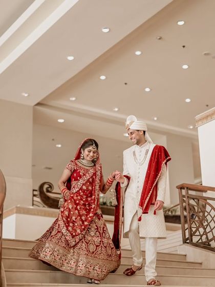 The grand descent. The couple walks down a beautiful spiral staircase after their ceremony, a perfect candid moment.