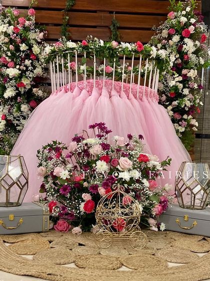 A close-up of the cradle decoration for baby Aaira's welcome party. The cradle is adorned with a pink tulle skirt and surrounded by an abundance of fresh flowers.