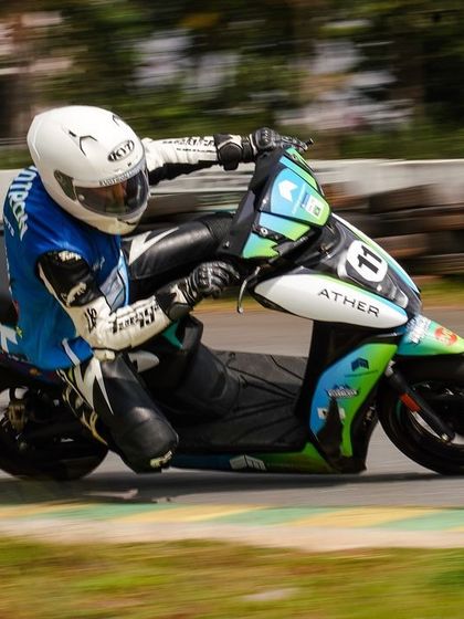 A rider in full racing gear skillfully navigates a corner on an Ather 450X. The event proved that electric scooters can be serious racing machines.