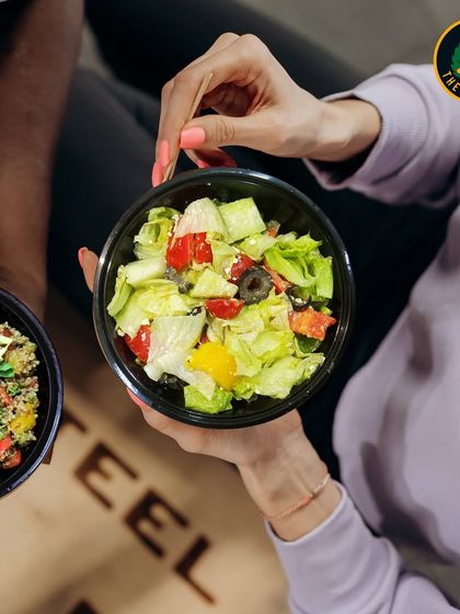 Fuel your body with goodness, one bite at a time. Here you can see two of my popular options, a quinoa salad and a classic Greek salad, ready to be enjoyed.