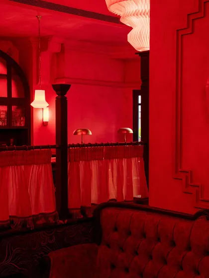A seating area with tufted sofas and sheer curtains, creating a softer, more relaxed zone within the vibrant space.
