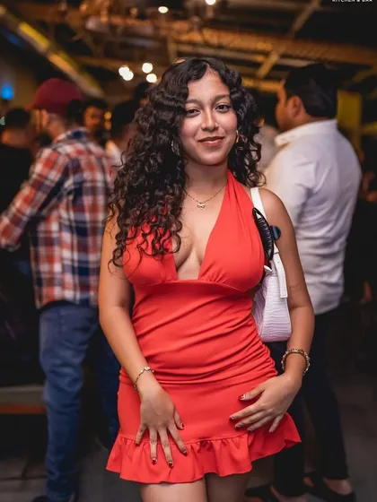 A guest in a stunning red dress, ready for a night of dancing.