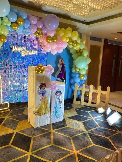 A different perspective of the Disney Princess party decor. This angle shows the light-up marquee number '1' and the placement of the themed pedestals in front of the shimmer wall.