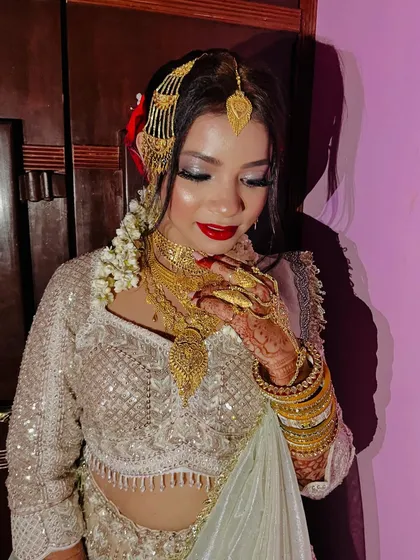 This close-up highlights the intricate gold jewelry and the flawless, glowing makeup. It's a look of pure elegance and sophistication.