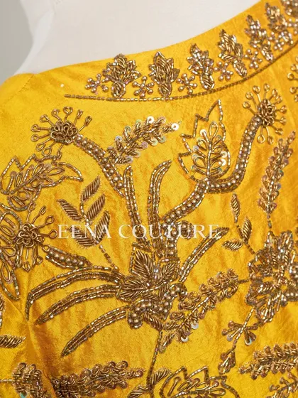 This sunshine yellow raw silk blouse is brought to life with meticulous hand embroidery by my talented artisans. The dense, traditional motifs in antique gold threadwork cover the back and sleeves, creating a piece that radiates warmth and luxury.
