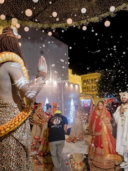 A unique Shiv-Parvati themed Jaimala. An artist dressed as Lord Shiva blesses the couple as they enter, with artificial snow falling around them to create a divine, Kailash-like atmosphere.
