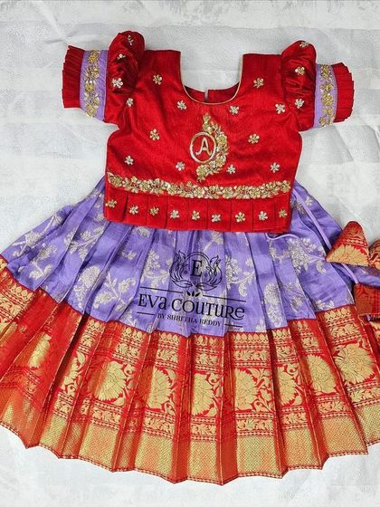 A newborn-sized Pattu Pavadai with a custom embroidered initial 'A' on the blouse, a personal touch I can add to any outfit.