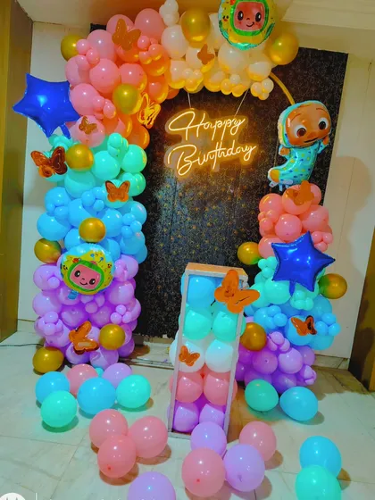 A Cocomelon-themed birthday backdrop using two balloon columns and a neon sign, perfect for a smaller space.