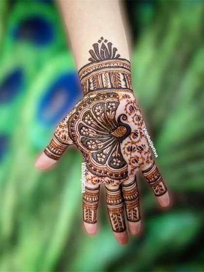 A stunning peacock design on the back of the hand. The intricate details of the feathers against the peacock-feather background make this a true work of art.