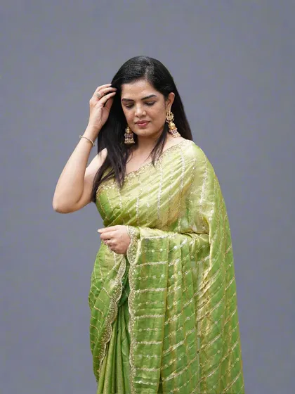A candid-style shot of the lime green organza tissue saree, highlighting its easy-to-carry and glamorous feel.