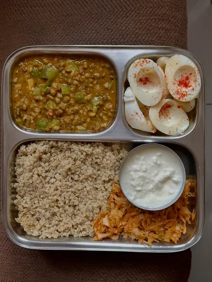 This plate features quinoa, moong dal, cabbage palya, curd, and boiled egg whites. It's a great example of a balanced, high-protein, and gluten-free meal.