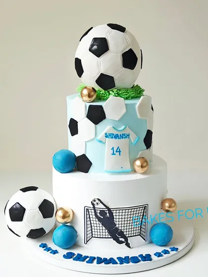Perfect for a football fan, this two-tiered cake features a fully edible chocolate soccer ball on top, filled with assorted chocolates for a fun surprise. The design includes a custom jersey number and a silhouette of a player, making it a personalized tribute to the beautiful game.