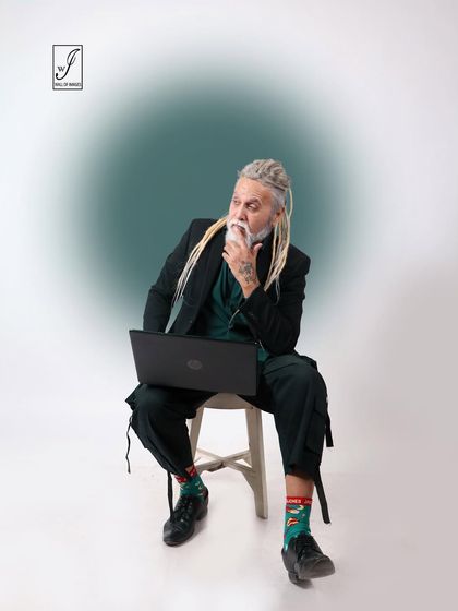 A thoughtful, seated pose that suggests creativity and focus, perfect for a personal branding or lifestyle shoot.