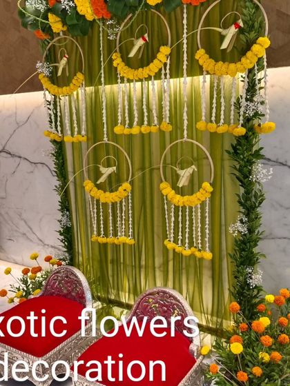 A modern Haldi or Puja seating area. We used hoops decorated with marigolds and hanging tuberoses against a backdrop of sheer green drapes for a fresh and contemporary look.