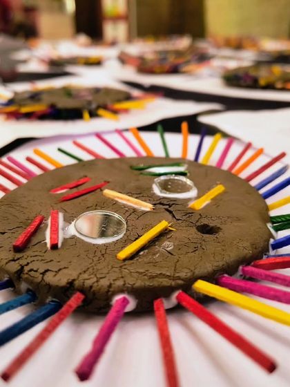 A finished clay sun creation from our toddler class. The combination of natural clay, colorful sticks, and shiny mirrors makes it a tactile delight.