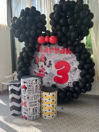 A modern take on a Minnie Mouse theme, using black, white, and yellow with graphic-printed plinths for a unique look.