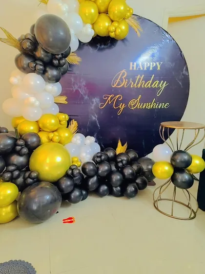 A close-up of the black, white, and gold balloon arrangement for the "My Sunshine" birthday theme.
