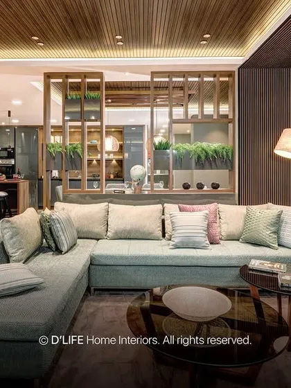 This living room design uses a light blue sectional sofa, a warm leather armchair, and a striking chevron-patterned wall to create a space that is both stylish and comfortable.