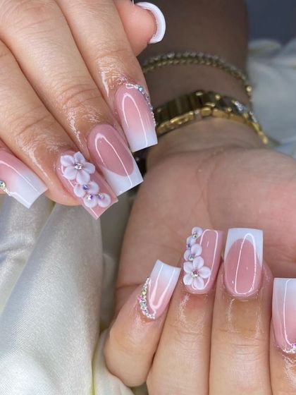 A perfect French ombre on square nails, beautifully decorated with 3D flowers and rhinestone-lined cuticles.