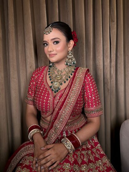 The complete look, showing how our temple jewellery set complements the rich red of her bridal outfit.