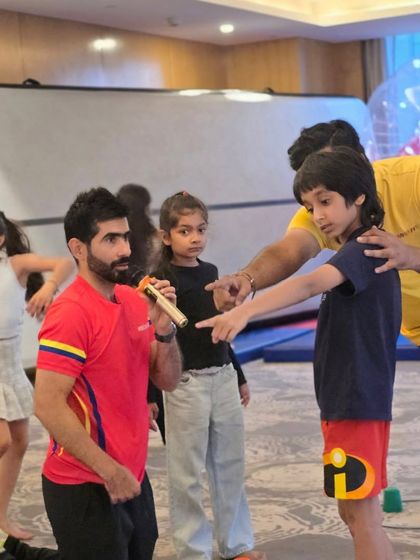 Our coach, a trained gymnast himself, interacts with the kids during a gymnastics-themed party. His expertise ensures a fun and authentic experience for everyone.