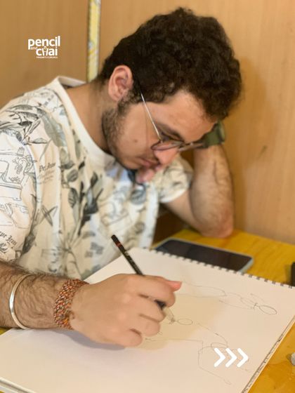 A student leans in, concentrating on the details of his sketch. These moments of intense focus are where real learning happens.